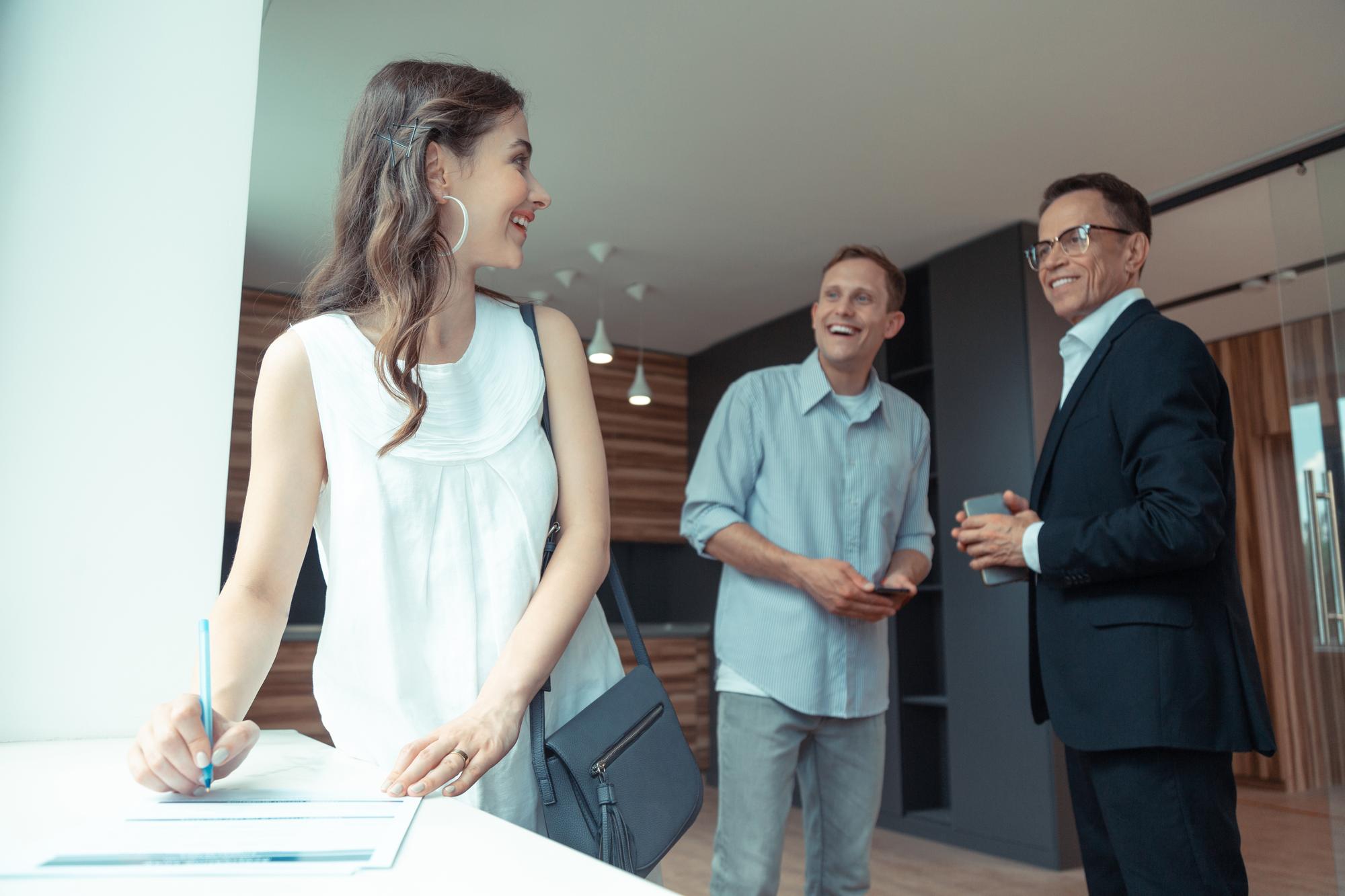 Agent imobiliar discutând cu proprietarul într-un birou luminos